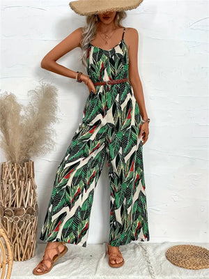 Botanical print cami jumpsuit in dark green with wide legs and a braided belt.