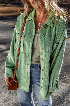 Green corduroy overshirt with button cuffs and chest pockets, styled with a henley and jeans.