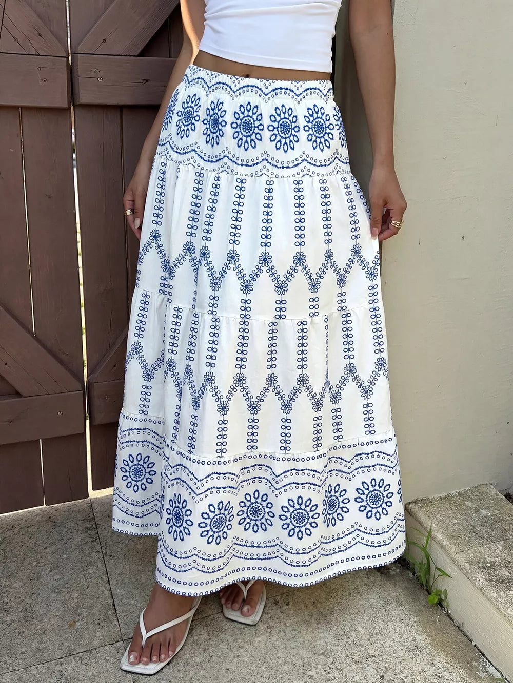 Bohemian maxi skirt with blue floral embroidery and tiered ruffles.