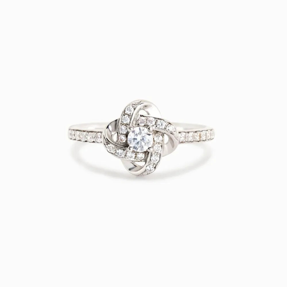 Silver ring with intertwined crystal knot design and pavé band