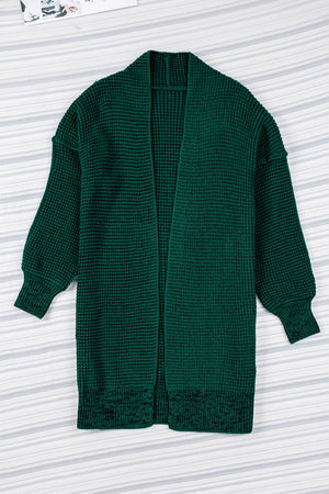 Textured puff sleeve open cardigan in Black Forest green acrylic with waffle knit and ribbed cuffs.