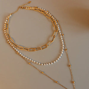 Gold layered necklace with chunky chain, pearls, and bead accents