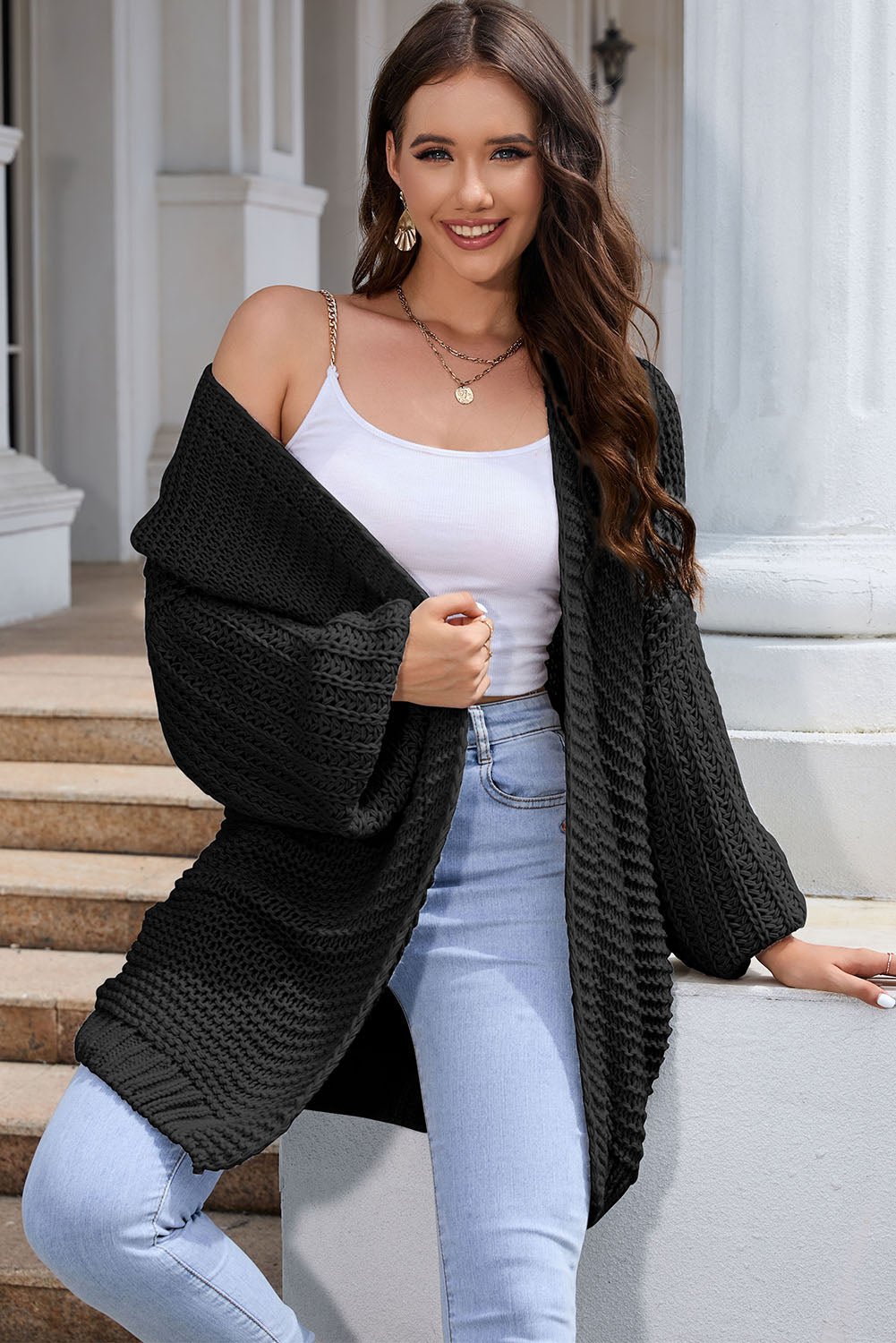 Black textured knit cocoon cardigan with balloon sleeves and open front.