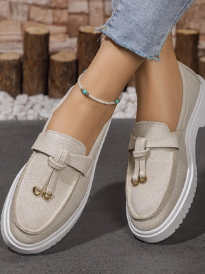 Beige suede loafer slides with tassel detail and gold hardware.