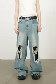 Distressed wide-leg denim jeans in medium wash with fraying and ripped details.