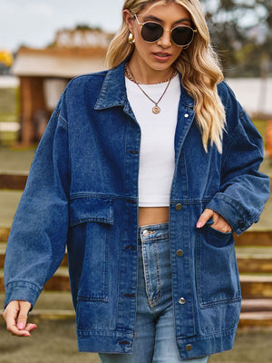 Oversized denim trucker jacket in medium blue wash with collared neck and chest pockets.