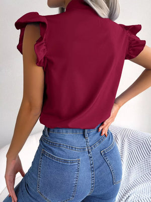 Burgundy maternity blouse with ruffle sleeves and pussy-bow neckline, worn with jeans.
