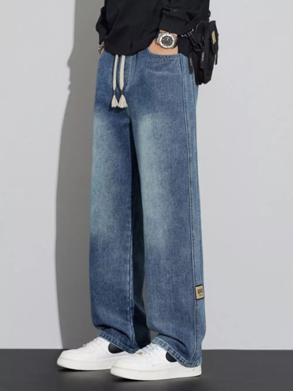 Men's blue wide-leg jeans with drawstring and patch detail