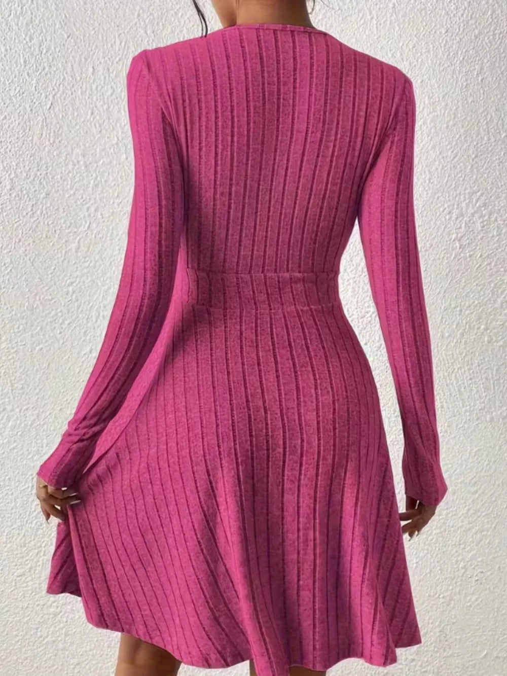 Fuchsia pink ribbed wrap mini dress with long sleeves and A-line skirt.