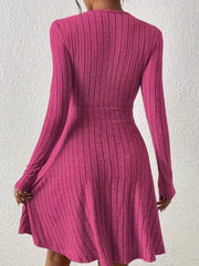 Fuchsia pink ribbed wrap mini dress with long sleeves and A-line skirt.