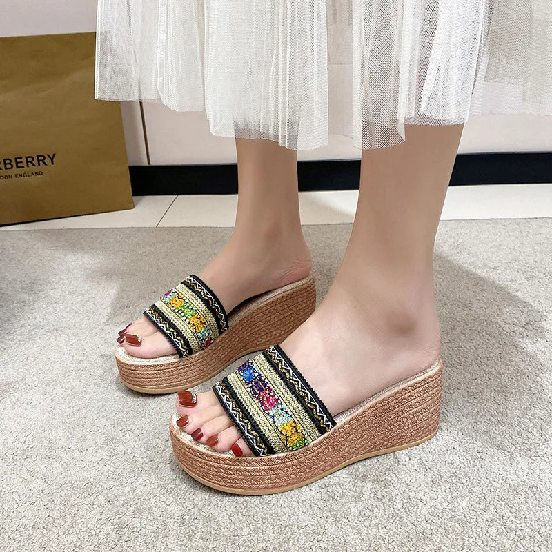 Embroidered platform wedge slides in beige with colorful woven detail and espadrille wedge.