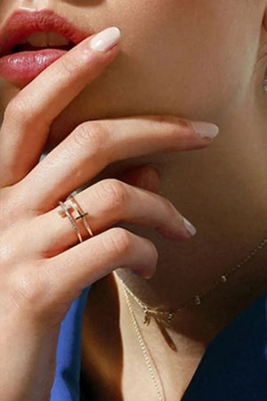 Double band ring with cross embellishment in gold, featuring delicate sparkle details.