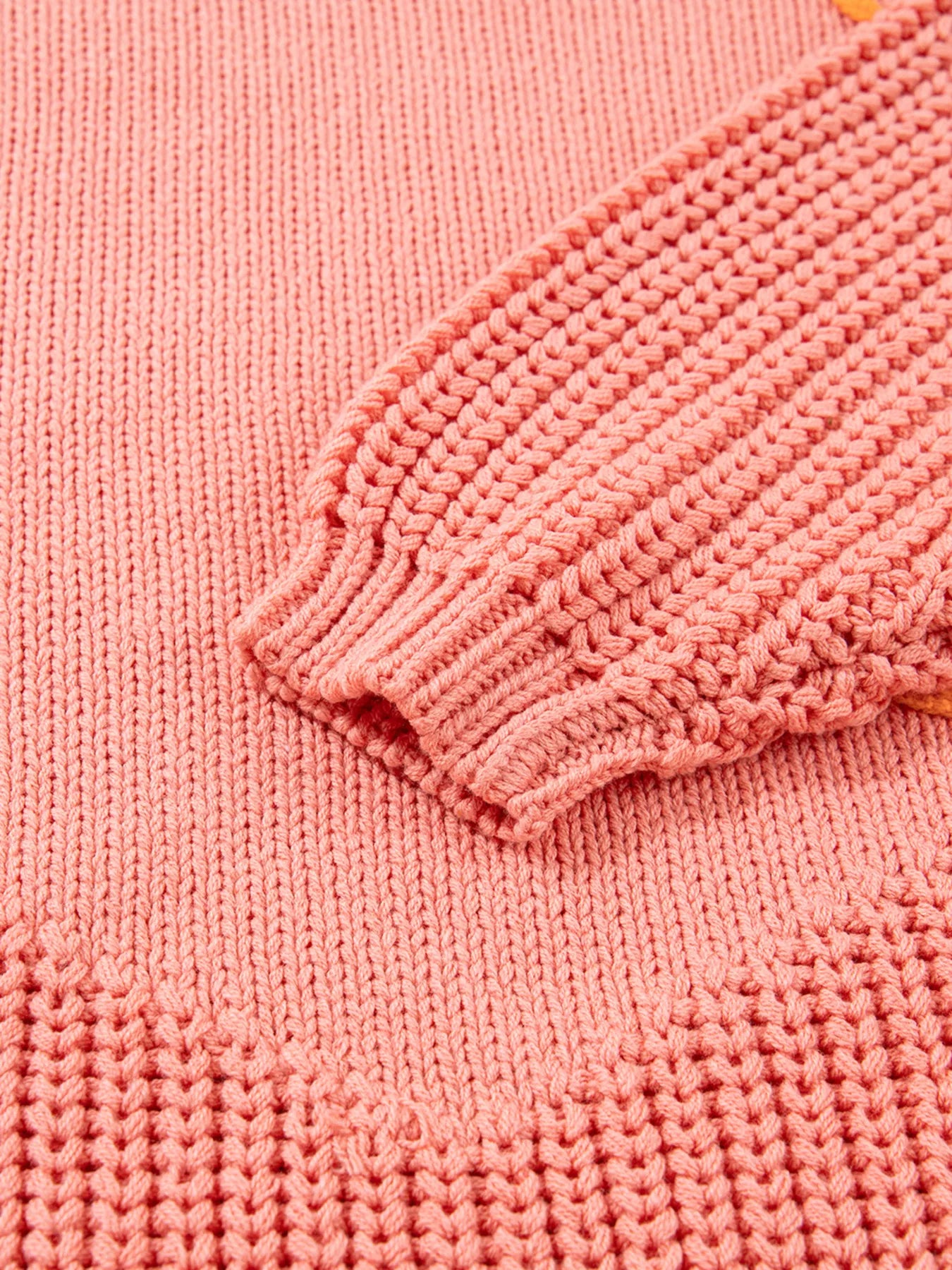 Burnt Coral knit sweater with textured sleeve cuff and hem detail.