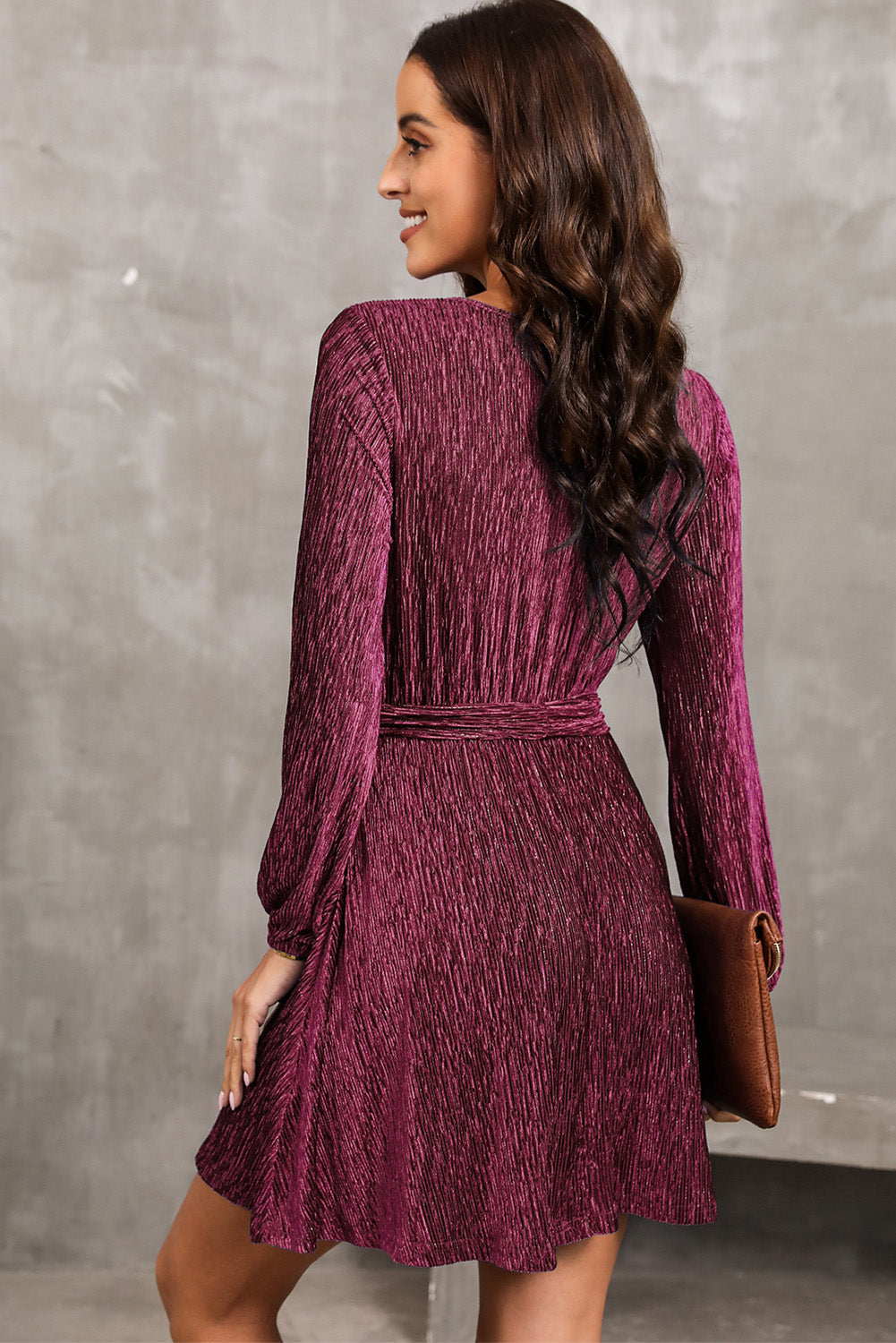 Wine textured pleated mini dress with long sleeves and a tie waist.