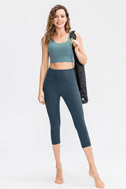 Deep Teal Sculpting Capri Leggings with phone pocket detail, breathable fabric.