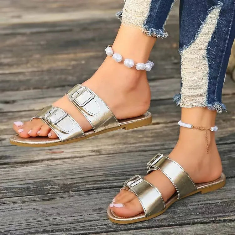 Metallic buckle slide sandals in silver with double straps and adjustable buckles.