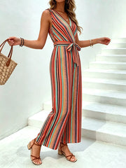 Striped wide-leg jumpsuit with tie waist, V-neck, sleeveless, and wrap closure in orange and red hues.