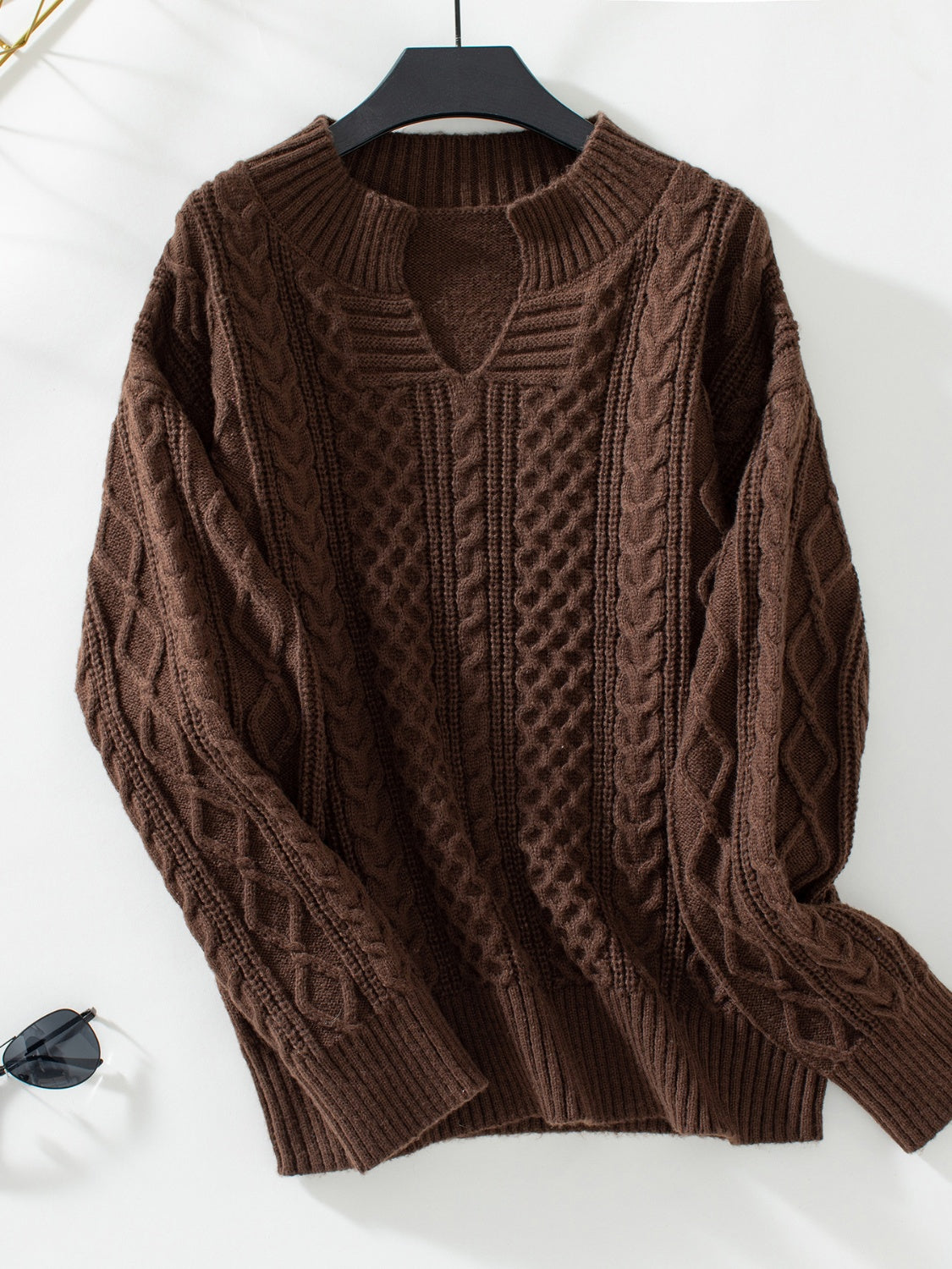 Chocolate cable knit sweater with keyhole neck and ribbed cuffs.