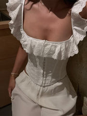 White eyelet corset tank top with ruffle trim and hook-and-eye closure.