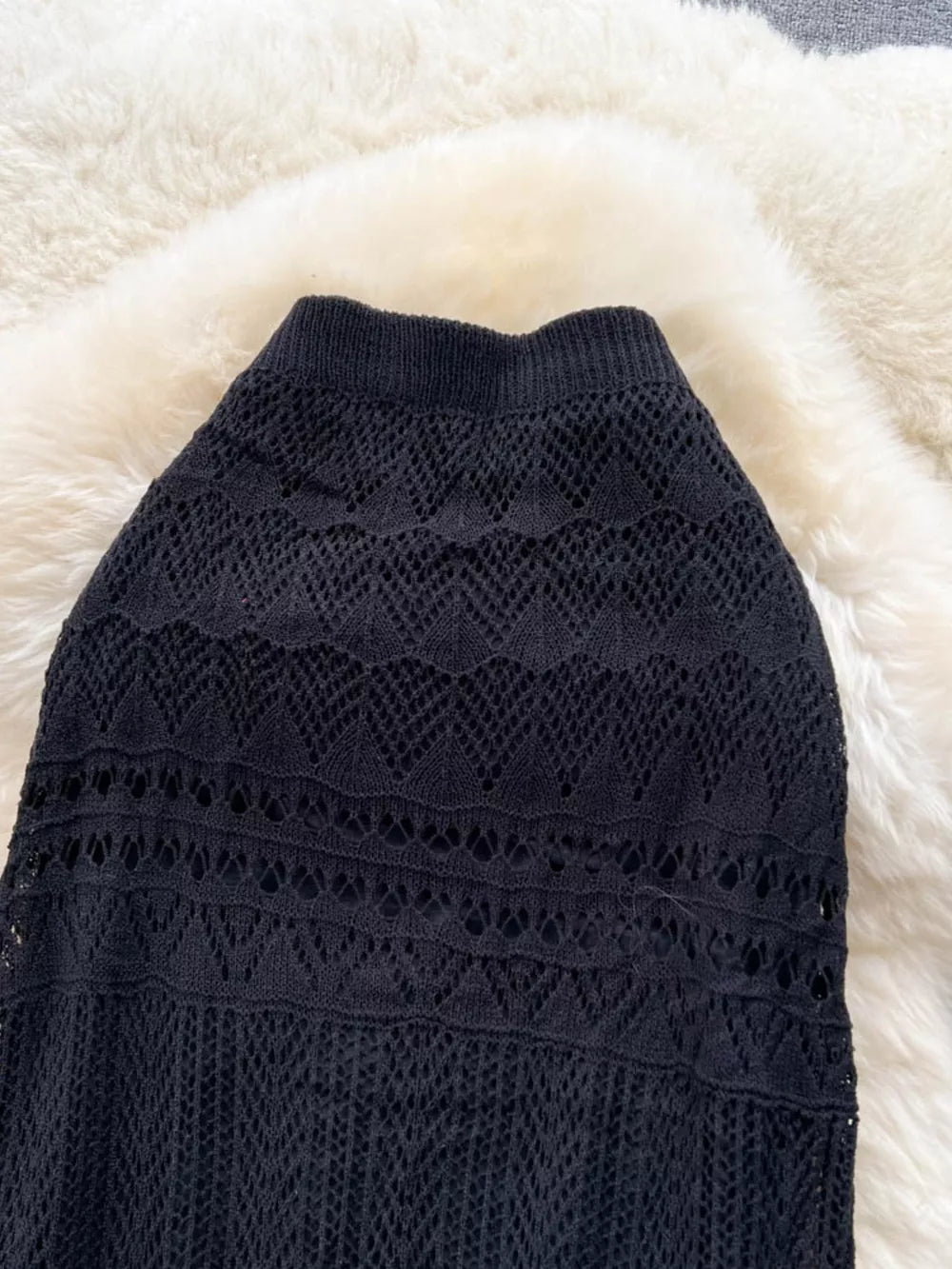 Black openwork maxi skirt with intricate knit patterns and a ribbed waistband.