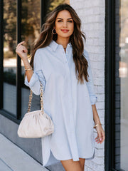 Oversized Misty Blue cotton shirt dress with button front and curved hem.