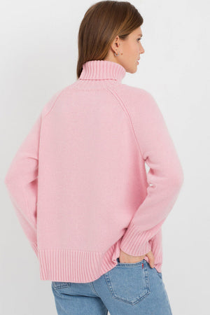 Blush pink cashmere turtleneck sweater with raglan sleeves and ribbed cuffs and hem.