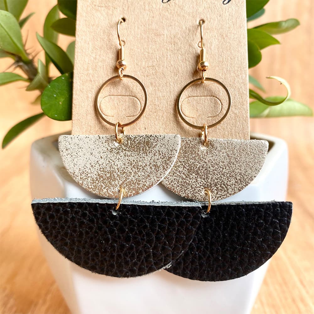 Textured leather half-moon earrings in white and black with gold hoops.