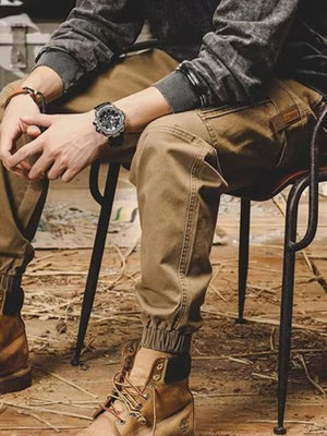 Men's khaki relaxed fit cargo pants with elastic cuffs and a patch detail.
