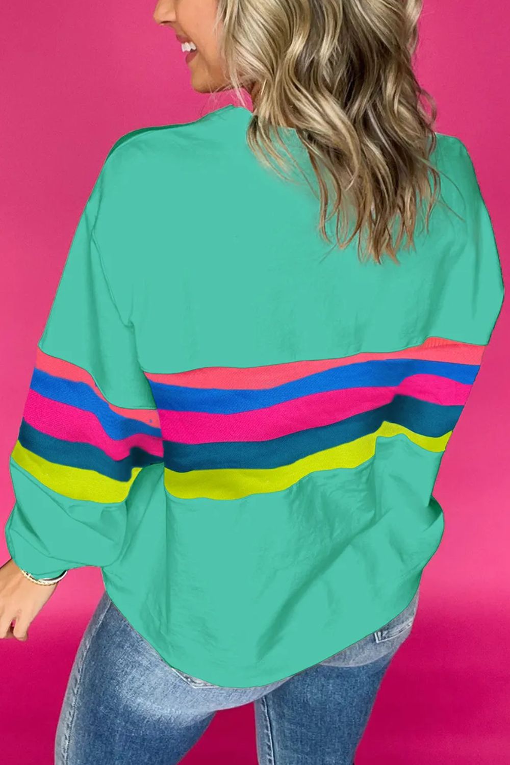 Turquoise crewneck sweatshirt with colorful horizontal stripes on sleeves and torso.