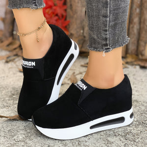 Black round toe platform slip-on sneakers with white soles and "SHION" detail.