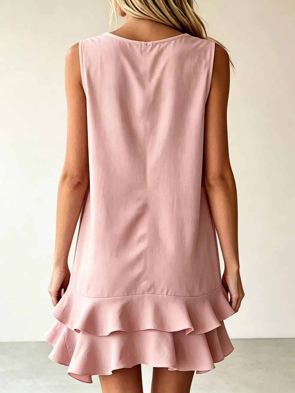 Pink tiered ruffle mini dress with a sleeveless, A-line cut.