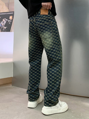 Men's relaxed fit jeans in dark wash denim with all-over woven motif pattern and distressed details.