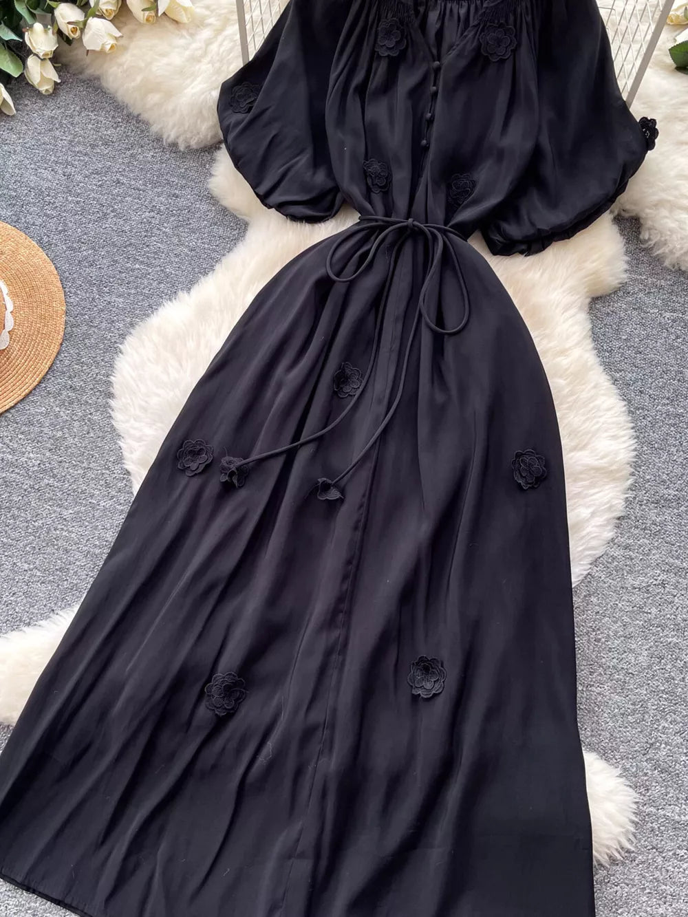 Black floral maxi dress with puff sleeves and tie waist.