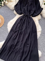 Black floral maxi dress with puff sleeves and tie waist.