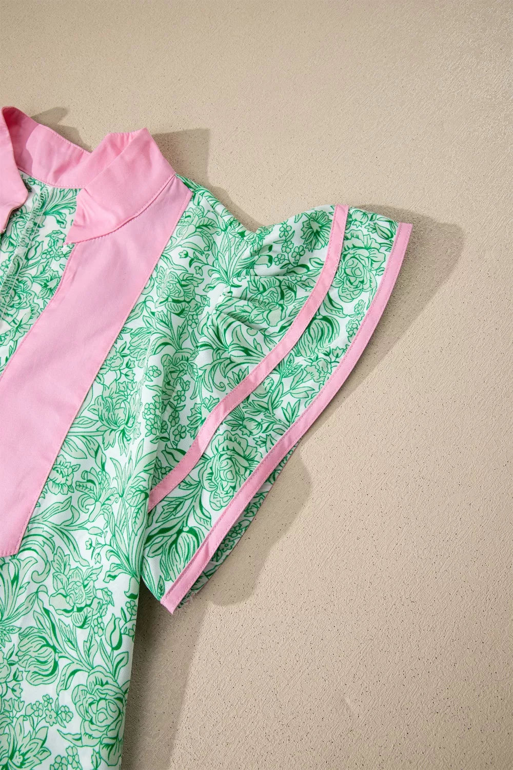 Botanical print midi dress with flutter sleeves, pink trim, and collar.
