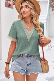 Sage eyelet V-neck blouse with lace trim on neckline and sleeves.