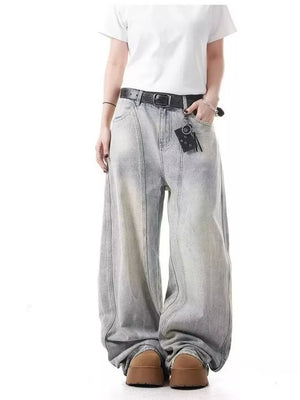 Baggy light wash denim jeans with vertical seam details and a belted waist.