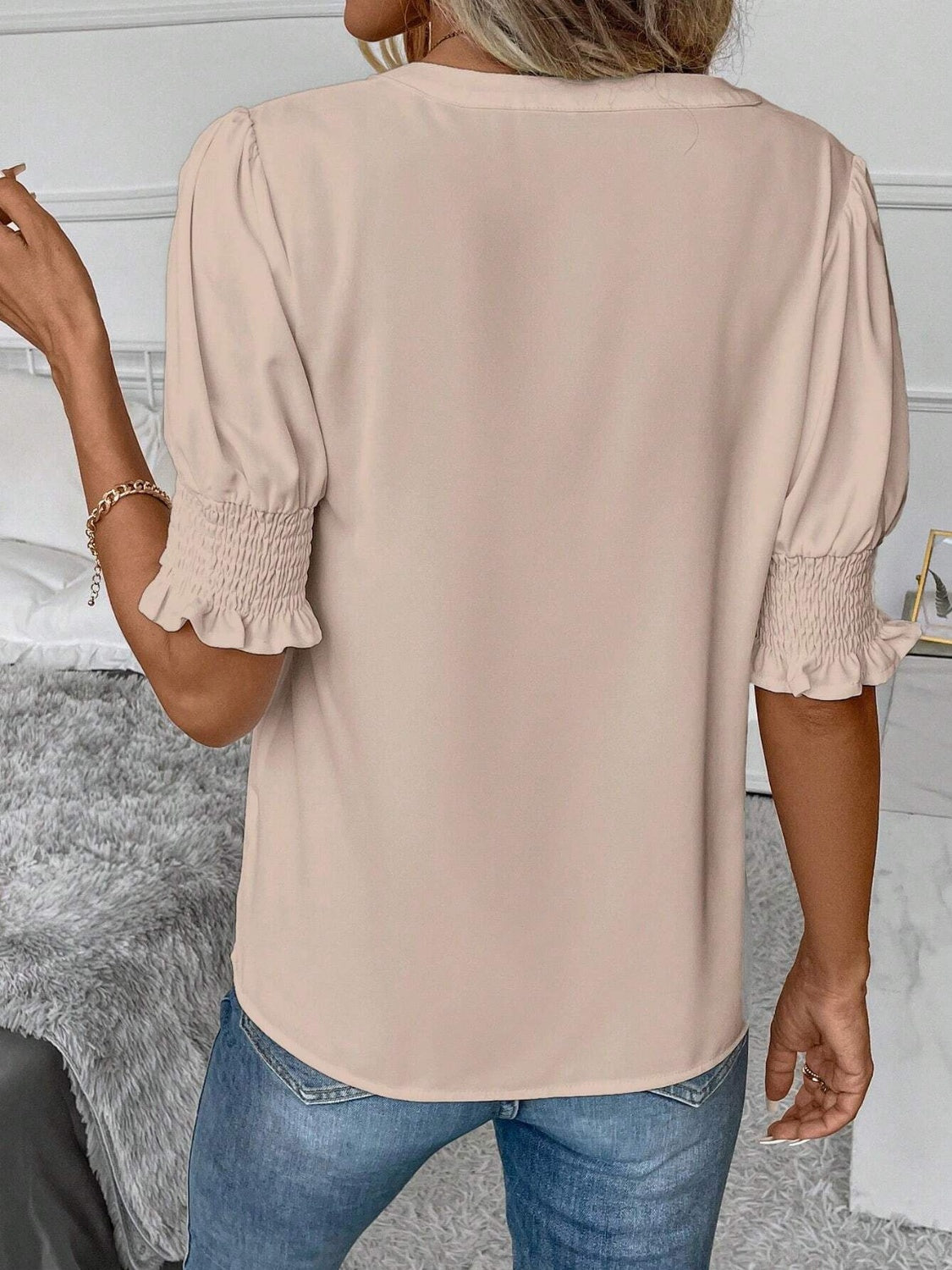 Tan shirred sleeve blouse with a V-neckline and ruffle cuffs.