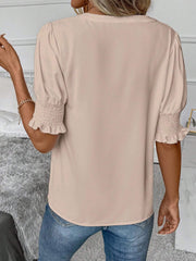 Tan shirred sleeve blouse with a V-neckline and ruffle cuffs.