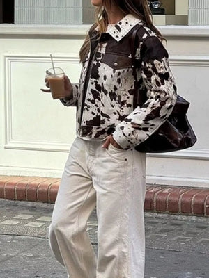 Buttoned collared jacket in cow print with brown accents and button front.