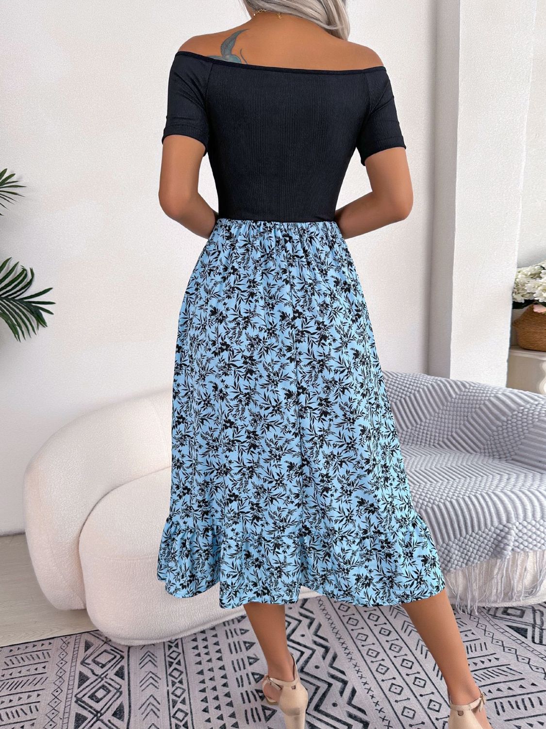 Floral print off-shoulder midi dress in sky blue with black floral pattern and ruffled hem.