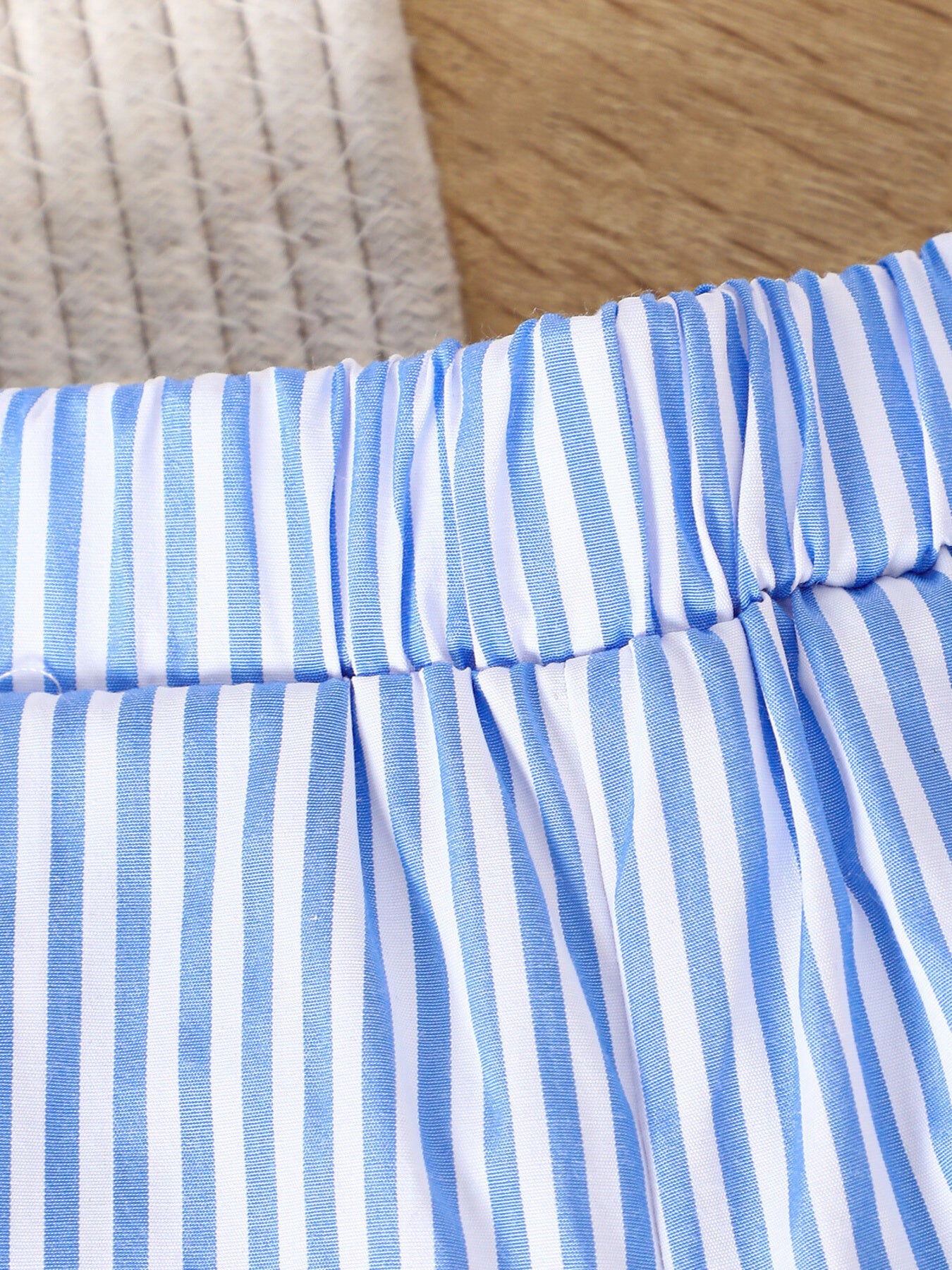 Baby shorts with blue and white vertical stripes and elastic waistband