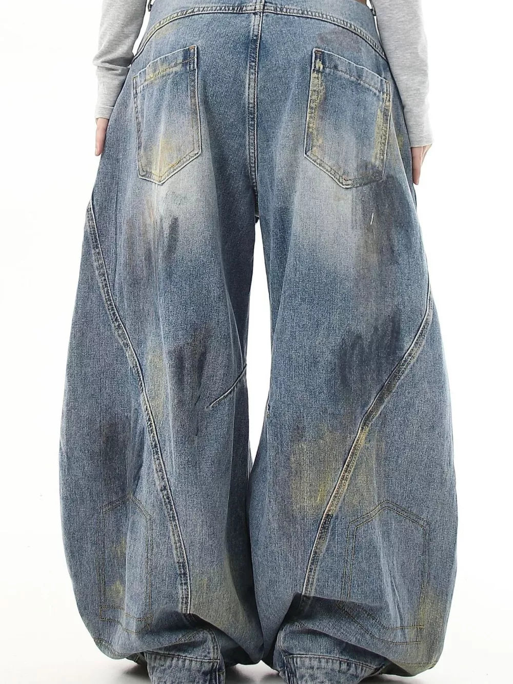 Washed blue denim wide-leg jeans with distressed pocket detail and baggy fit.