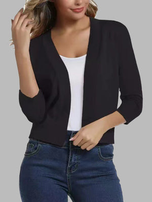 Black open-front cropped cardigan with elbow-length sleeves worn over a white tank top.