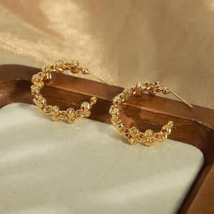 Gold textured orb C-hoop earrings with a beaded chain design.
