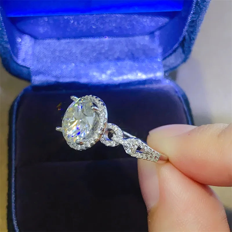 Silver halo moissanite ring with twisted band and pavé details.