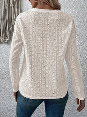 White long sleeve knit top with geometric eyelet pattern and v-neck.