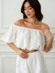 White off-shoulder cropped top and shorts set in textured cotton, featuring puff sleeves and elastic waist.