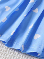 Blue baby dress with white heart print and pleated hem detail.