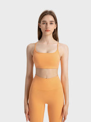 Strappy back active crop top in peach with a scoop neckline.